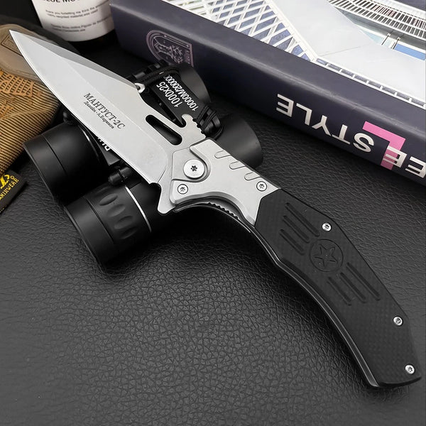 Folding knife with flashlight attachment on a textured surface