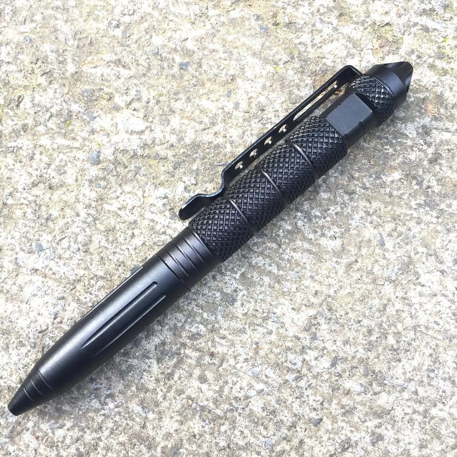 Black tactical pen on a textured surface